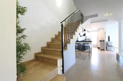 a staircase leading to a living room and a dining room at Global Vacacional, Impresionante ático para 8 personas en Canet d'en Berenguer in Canet de Berenguer