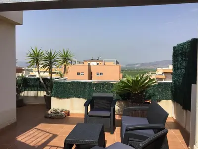 a balcony with chairs and a view of a building at Global Vacacional, Impresionante ático para 8 personas en Canet d'en Berenguer in Canet de Berenguer