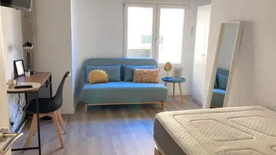 a bedroom with a blue chair and a bed and a desk at Valencia Playa in Valencia