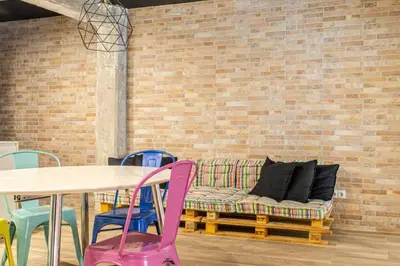 a table and chairs with a couch against a brick wall at Valencia Playa in Valencia
