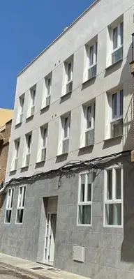 a large gray building with windows on the side of it at UIM Mediterraneo Poeta 3 Wifi in Puerto de Sagunto