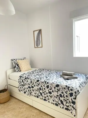 a bedroom with a bed with a blue and white comforter at UIM Mediterraneo Poeta 3 Wifi in Puerto de Sagunto