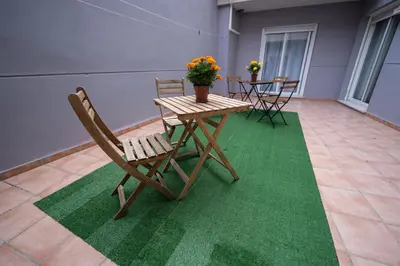 a wooden table and chairs on a green rug at Apartamento San cayetano in Torrent