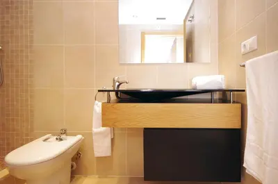 a bathroom with a sink and a toilet and a mirror at Apartamentos Port in Valencia