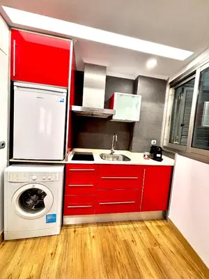 a kitchen with red cabinets and a washing machine at Casa del Carmen in Valencia