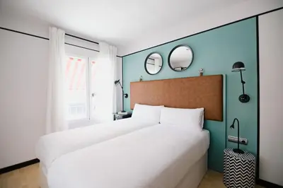 a bedroom with a large white bed and two mirrors at The Little Corner B&B in Valencia
