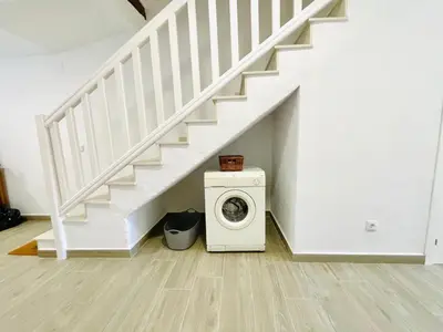 a washing machine in a room under a staircase at JERICA ALOHA in Jérica