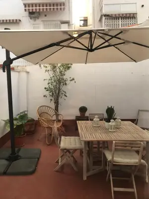 a table and chairs and an umbrella in a room at 2 Apartamento TERRAZA Free Wifi in Valencia