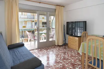a living room with a couch and a tv and a crib at Mar y Montana 6to 97 in Cullera