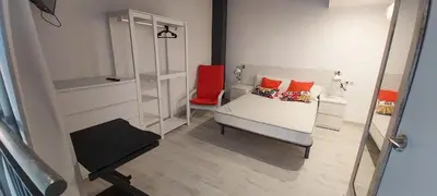 a bedroom with a bed with orange pillows and a mirror at valencialoft in Valencia