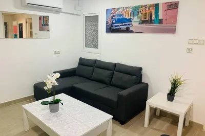 a living room with a black couch and a table at VALENCIA / PLAYA CABANYAL, PUERTO, CUIDAD ARTES in Valencia