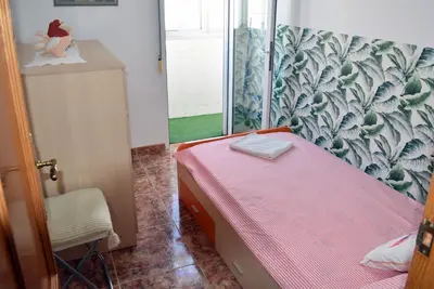 a small bedroom with a pink bed and a window at FLAMING 2 in Cullera