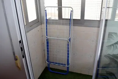 a blue shower rack in a bathroom next to a window at FLAMING 2 in Cullera