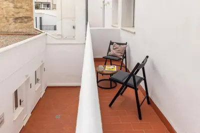 a small balcony with two chairs and a table at Líbere Valencia Abastos in Valencia