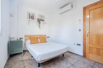 a small bedroom with a bed and a wooden door at Maritim Horizon House Port of Valencia in Valencia