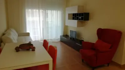 a living room with a table and a red chair at Nova Almenara. Ideal para familias in Barrio-Mar