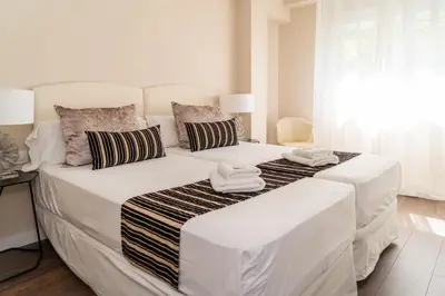 a white bedroom with two beds with towels on them at MD Galán Street in Valencia
