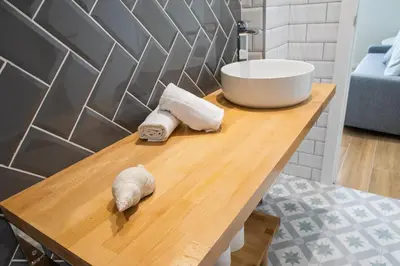 a bathroom with a sink and towels on a wooden table at FLORIT FLATS - Valencia Port Rooms I in Valencia
