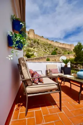 a patio with a chair and a table with a view at Casa El Cielo, in the heart of Old Town in Chulilla