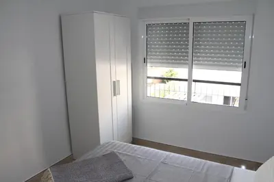 a bedroom with a bed with two tables at Haus LIDZBARSKI in Burriana