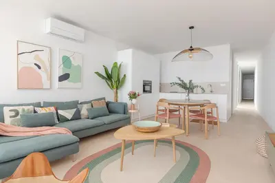a living room with a blue couch and a table at Marsalada - Ground floor front line beach apartment in Playa de Mar