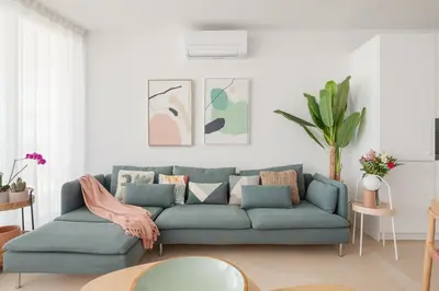 a living room with a blue couch with pillows at Marsalada - Ground floor front line beach apartment in Playa de Mar