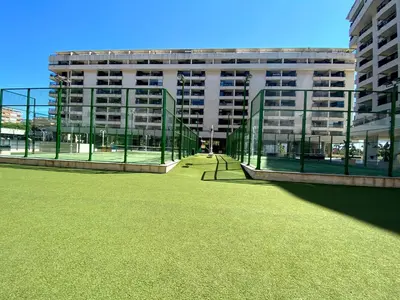 a large building with a green lawn in front of it at M & B Beach Apartment in Valencia