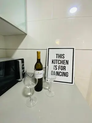 a bottle of wine and two wine glasses on a counter at M & B Beach Apartment in Valencia