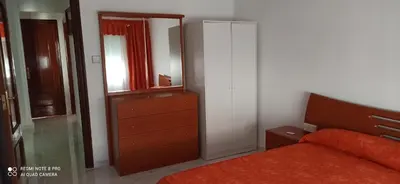 a bedroom with a bed and a dresser and a mirror at Saint Germain 2C in Cullera