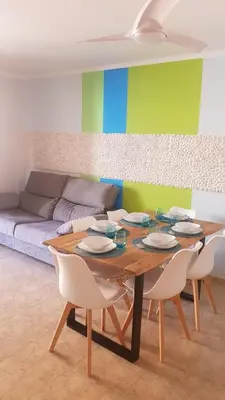 a dining room with a table and chairs and a couch at SUN&BEACH Moncofar in Moncófar