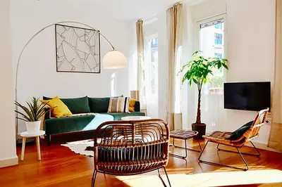 a living room with a green couch and chairs at Hola Valencia - Holiday Apartments in Valencia