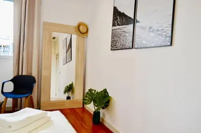 a room with a chair and a mirror on a wall at Hola Valencia - Holiday Apartments in Valencia
