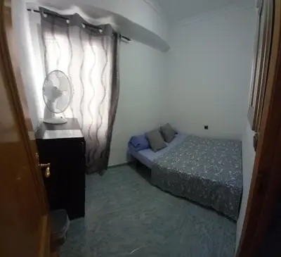 a small bedroom with a bed and a fan at habitación pequeña en piso compartido con 2 adultos in Valencia