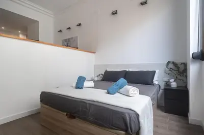 a bedroom with a bed with blue pillows on it at Exclusivos Lofts en Plaza del Ayuntamiento in Valencia