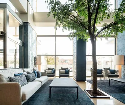 a lobby with two chairs and trees and a sign at Ilunion Valencia 4 in Valencia