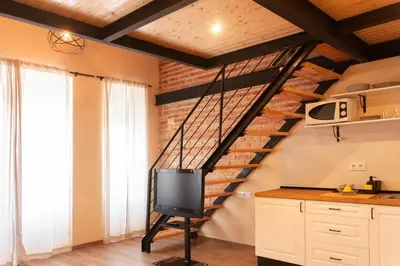 a tv on a stand in a kitchen with a staircase at Marittimo Apartments in Valencia