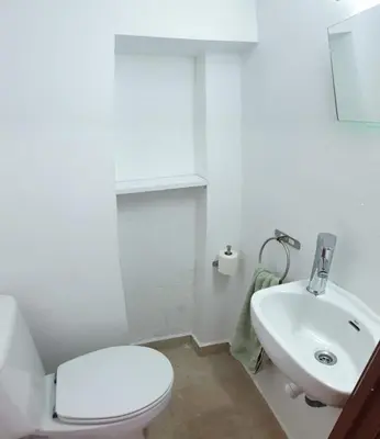 a white bathroom with a toilet and a sink at Casa Castillo de la Estrella in Segorbe