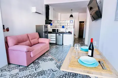 a living room with a pink couch and a table at Arenas beach 2 in Valencia
