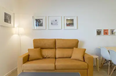 a living room with a brown couch and a table at Apartamentos Mercado Central in Valencia