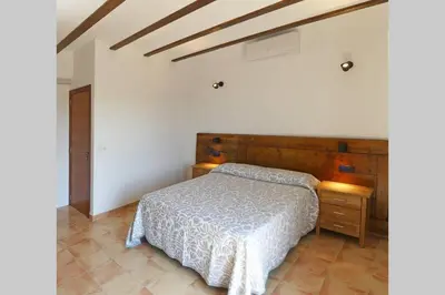 a bedroom with a bed and a wooden headboard at Ca Buganvilla. El corazón de la huerta valenciana in Meliana