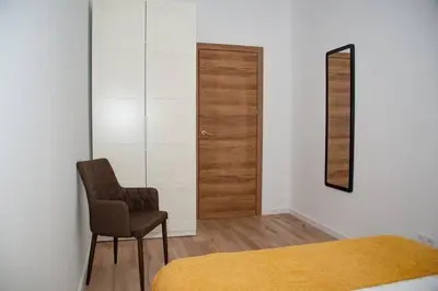 a bedroom with a bed and a chair and a mirror at Soraya's Place - Chopín 1 in Valencia