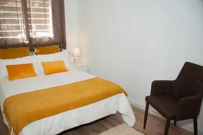 a bedroom with a large bed and a chair at Soraya's Place - Chopín 1 in Valencia