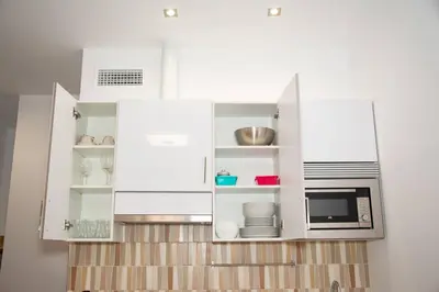a kitchen with white cabinets and a microwave at Soraya's Place - Chopín 1 in Valencia