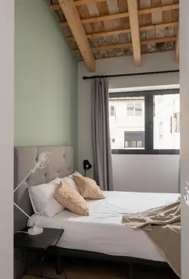 a bedroom with a large bed with a window at Líbere Valencia Jardín Botánico in Valencia