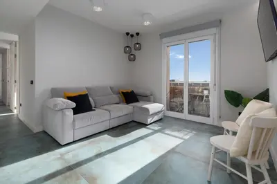 a living room with a couch and a large window at Your home at Valencia, Marina Real in Valencia