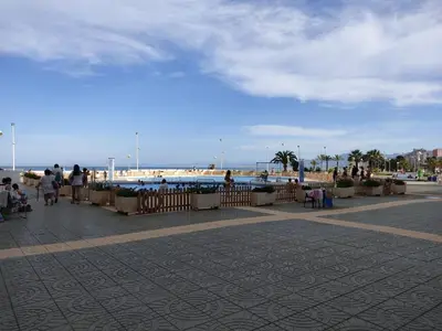 a group of people walking on a sidewalk near the beach at Apartamento en El Prado in Cullera