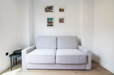 a white couch in a living room with a table at VLC HOST- Eixarchs in Valencia