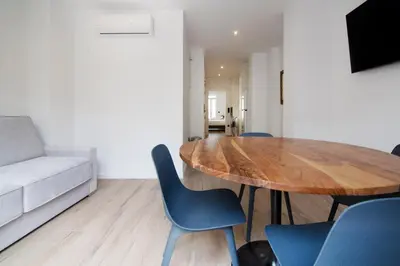 a living room with a wooden table and blue chairs at VLC HOST- Eixarchs in Valencia