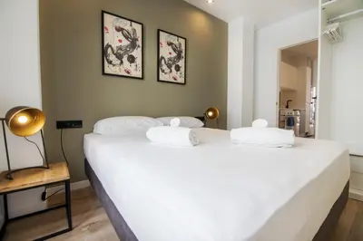 a bedroom with two beds with white sheets at VLC HOST- Eixarchs in Valencia