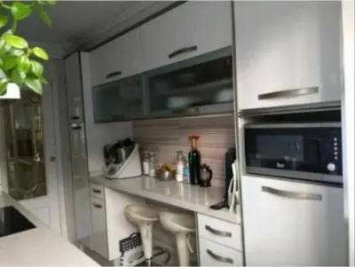 a kitchen with white cabinets and a counter with a microwave at Comoda y moderna HABITACION DOBLE in Valencia